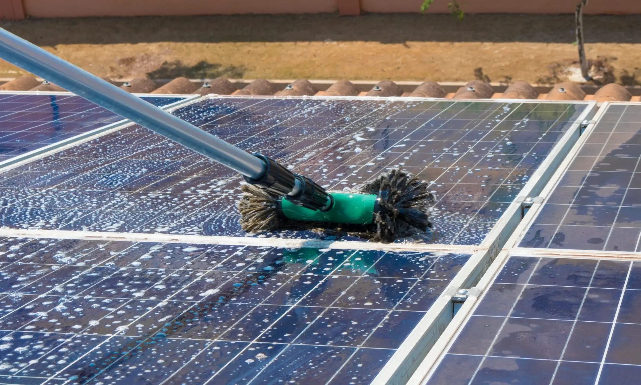 A professional cleaning solar panels with specialized tools